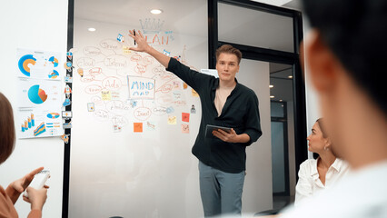 Wall Mural - Professional male leader presents start up project by using mind map, colorful sticky notes and business statistic graph with confident while investor listening carefully. Immaculate.