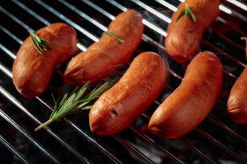 Wall Mural - Grilled sausages with rosemary on a grill.