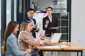 Wall Mural - Professional diverse business team presenting and discussing data charts and graphs during meeting in modern office.