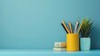 © Robert - Writing supplies in pen holder on blue desk on blue wall background