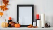 © PSCL RDL - Black mock frame with fall candles and pumpkin decor on a white shelf. autumnal idea frame for a portrait against a white wall