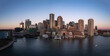 © AmazingAerialAgency - Aerial view of urban skyline at sunset with waterfront and harbor, Boston, Massachusetts, United States.
