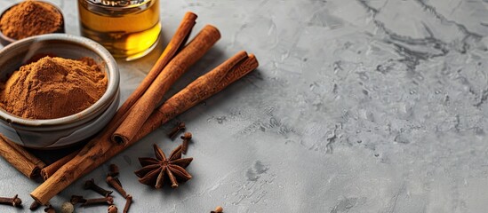 Fototapete - Cinnamon oil for various uses like cooking, aromatherapy, and skincare, displayed alongside cinnamon sticks on a grey backdrop with space for text in the image. Copy space image