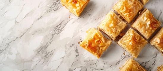 Poster - Sweet baklava displayed on a light grey marble surface from a top-down perspective, with room for text in the image. Copy space image. Place for adding text and design