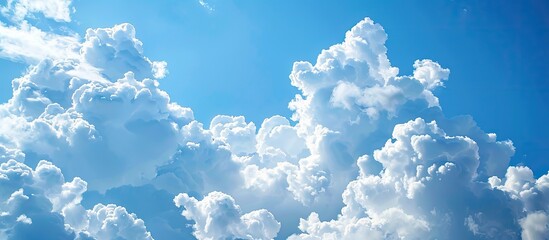 Poster - White fluffy clouds float in a clear blue sky providing a perfect textured background with ample copy space image for text.