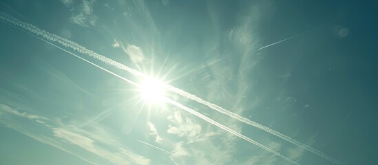 Aufkleber - Streaks left by airplanes in the clear sky with a bright sun and abundant copy space image.