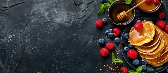 Poster - Russian cuisine concept depicted with pancakes, berries, and honey on a dark background for a visually appealing copy space image.