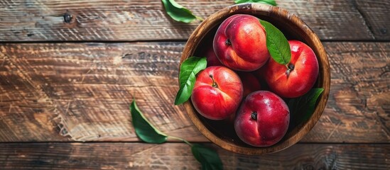 Poster - Top view of peaches in a bowl on a rustic wooden table with copy space image.