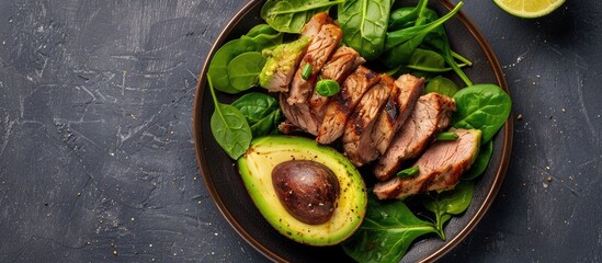 Wall Mural - Plate with meat, spinach, and avocado; copy space image.
