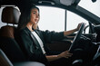 © standret - View from the side. Beautiful businesswoman is in the new car