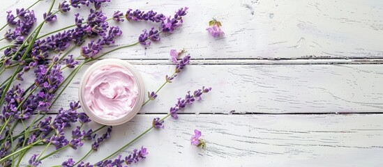 Poster - Pink moisturizer cream and purple lavender flowers on a rustic white wooden table with copy space image.