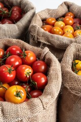 Wall Mural - Three bags of tomatoes are piled on top of each other. The bags are made of burlap and are filled with ripe tomatoes. Concept of abundance and freshness, as the tomatoes are ripe and ready to be eaten