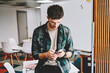 © BullRun - Young pensive smart hipster guy dressed in trendy clothes checking notification on smartphone while chatting in social networks.Male person sending feedback for popular website on modern telephone