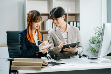 Two Asian businesswoman and man discuss investment project working and planning strategy