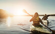 © Reese Coop/peopleimages.com - Couple, happy and lake outdoor for kayak or water sports in nature, paddling and rowing together for river journey. Man, woman and adventure date for bonding with love, fun and summer travel vacation