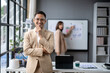 © Wasana - A man in a suit stands in front of a white board with a woman behind him