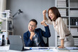 © Wasana - A man and a woman are standing in front of a desk with a laptop and a tablet