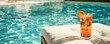 © peppastocker - A poolside lounge chair with a refreshing drink
