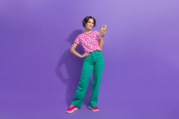 Wall Mural - Full body photo of attractive young woman hold telephone eshopping wear trendy pink clothes isolated on purple color background