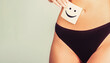 © Yevhen - Woman health. Closeup of healthy female with beautiful fit slim body in black panties holding card with happy smiley face in hands