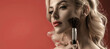 © Yevhen - Beautiful girl with blonde hair puts makeup on her face. Red background. Beauty concept. Make up in process. Girl hold blush blusher apply powder visage. Young woman powdering cheeks
