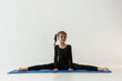 © standret - On the twine. Little girl in yoga clothes is on the fitness mat
