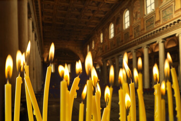 Wall Mural - Many church candles burning in temple, closeup