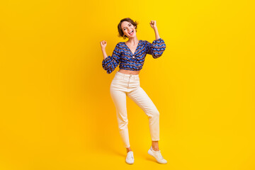 Sticker - Full body length of woman raised fists up celebrating her victory in best stylish outfit competition isolated on yellow color background