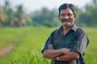 © darshika - Smiling Indian farmer in field with crossed hands.