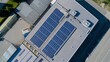 © The Little Hut - Aerial view of blue photovoltaic solar panels mounted on industrial building roof for producing clean ecological electricity Production of renewable energy concept : Generative AI