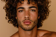 © Brastock Images / AI - Closeup of young Latino man with curly hair and beard isolated on pastel background Generative AI