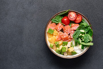 Wall Mural - Salmon bowl with spinach, rice, avocado, tomato, cucumbers on black background, top view. Poke bowl, healthy eating