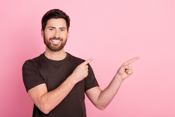 Wall Mural - Portrait of good mood man with bristle stylish hair wear brown shirt indicating at discount empty space isolated on pink color background