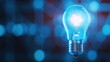 © Autaporn - A glowing blue lightbulb representing innovation, creativity, and bright ideas, set against a blurred blue background.