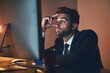 © NonVig/peopleimages.com - Man, night and tired at computer for proposal in office, burnout and stress for project planning. Male person, fatigue and mental health for deadline, stock market crash and 404 pc glitch on website