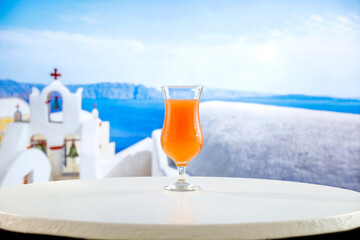 Sticker - Citrus fruit drink in a glass and blurred white building background in summer time. Summer table background.