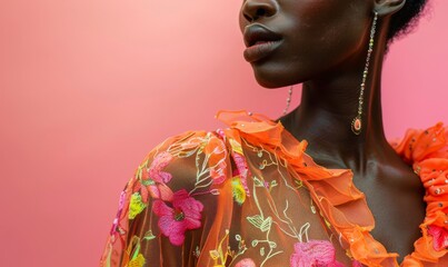 close-up portrait of african model in orange and pink floral embroidered dress against solid background in fashion photography style