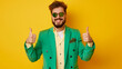 © Trendy Graphics - Happy confident bearded man in trendy funky green suit and sun glasses standing on yellow studio background, smiling and giving thumbs up with both hands