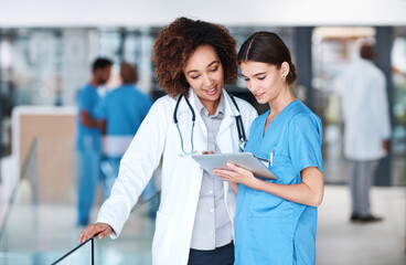 Women, doctor and nurse with tablet, internet and online reading for research, medical news and digital app. Advice, employees and healthcare with professional, tech and cooperation with connection