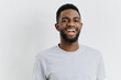 © SHOTPRIME STUDIO - Confident african american man smiling in casual grey tshirt on clean white background, radiating positivity and warmth