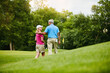 © Reese Coop/peopleimages.com - Mature, couple and walk back on golf field, outside and healthy fitness activity with golfers together with club. Relaxing, weekend break and care on sport course, nature exercise and people