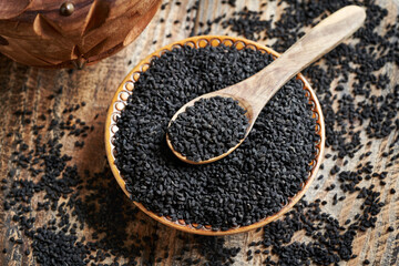 Poster - Black cumin or Nigella sativa seeds in a bowl and on a spoon