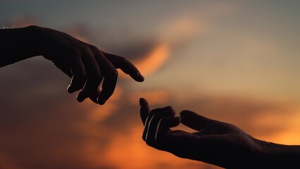 Reunion of loved ones, family happiness. Hands touching each other. People together. Finger Touching hands, silhouette of Hands in sky, couple feels love. Gentle touch with fingers of hands in sunset