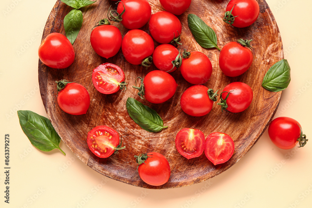 Wooden board with fresh cherry tomatoes and basil on orange background