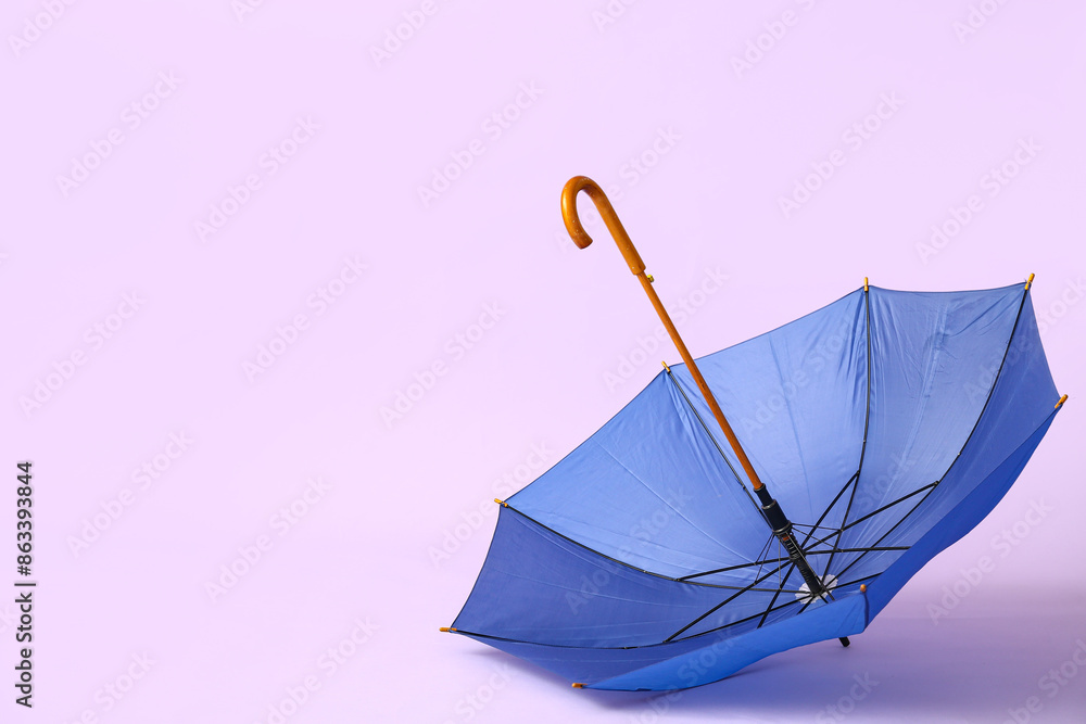 Blue stylish umbrella on lilac background