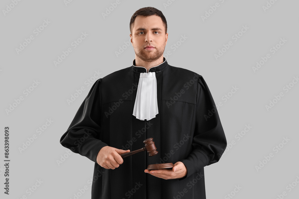 Male judge with gavel on light background
