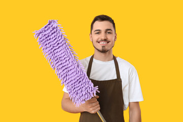 Poster - Male janitor with floor mop on yellow background