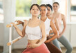 © JackF - Slender young female attendee of ballet courses doing plie standing by training bar with others
