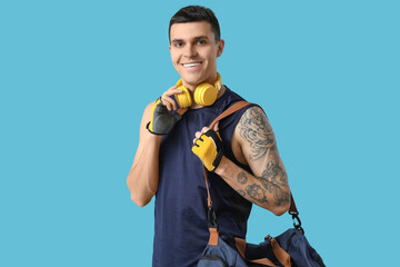 Sticker - Young man with sports bag and headphones on blue background