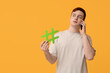© Pixel-Shot - Handsome young man with hashtag sign talking by mobile phone on yellow background